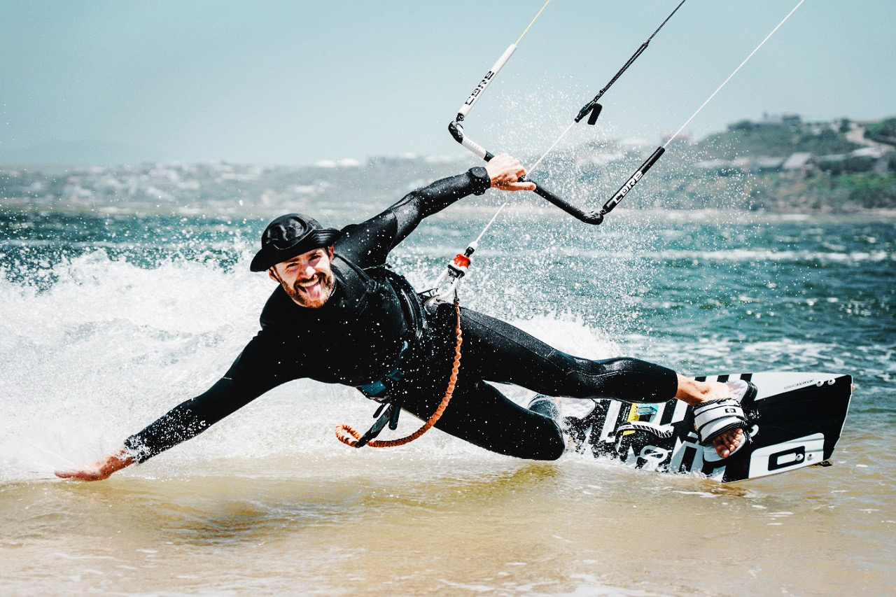 A kitesurfer riding in the Bloubergstrand chop with the kite overhead