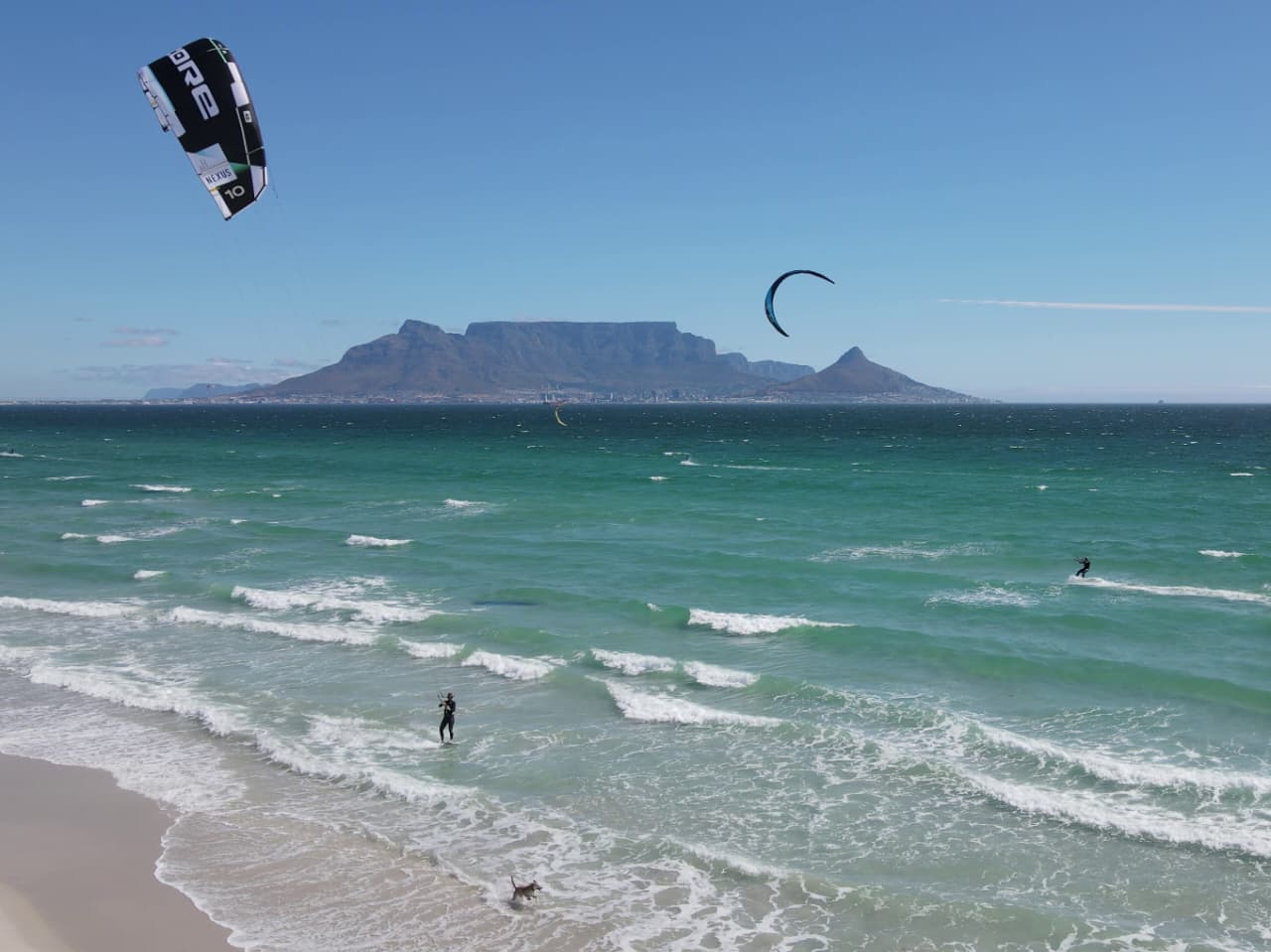 Aerial view of kitesurfers on the water off Bloubergstrand with Table Mountain in the distance
